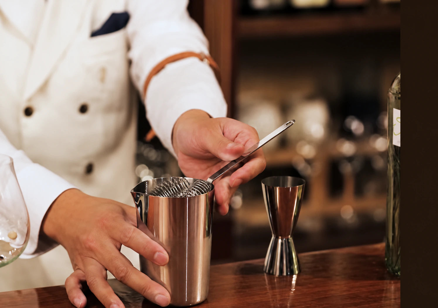 Holding a strainer by its handle above a tin
