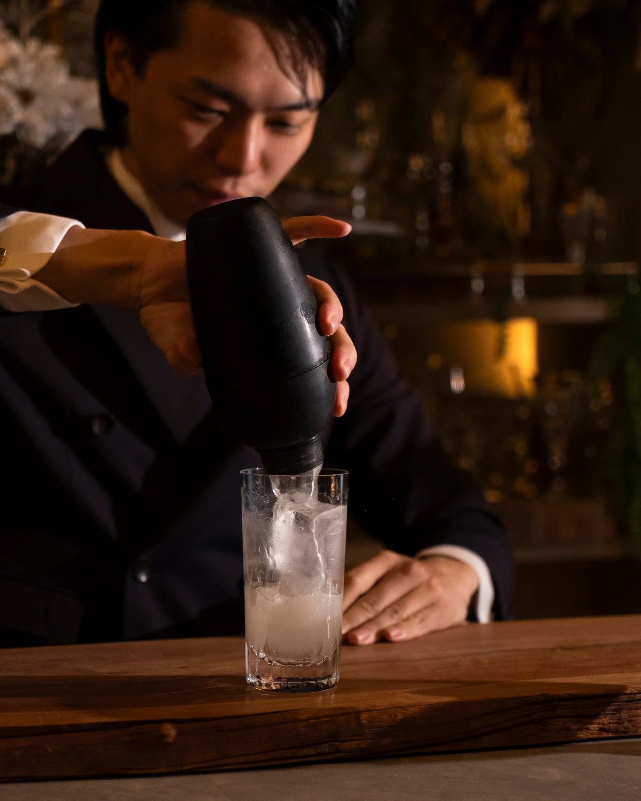 以 Charcoal Edition 雪克杯倒出調酒的手部特寫