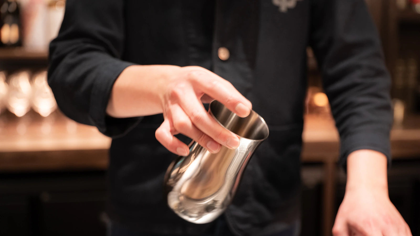 A bartender swirling a silver DC700 decanter at SG Tavern