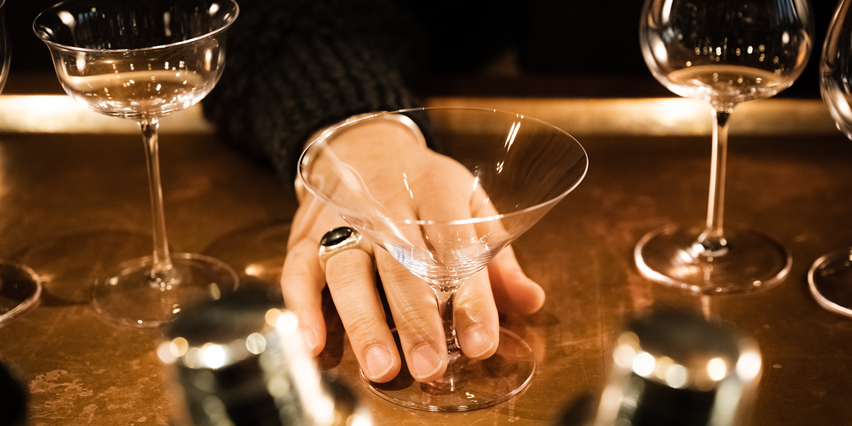 A SIP AND GUZZLE stemmed glass held in the hand