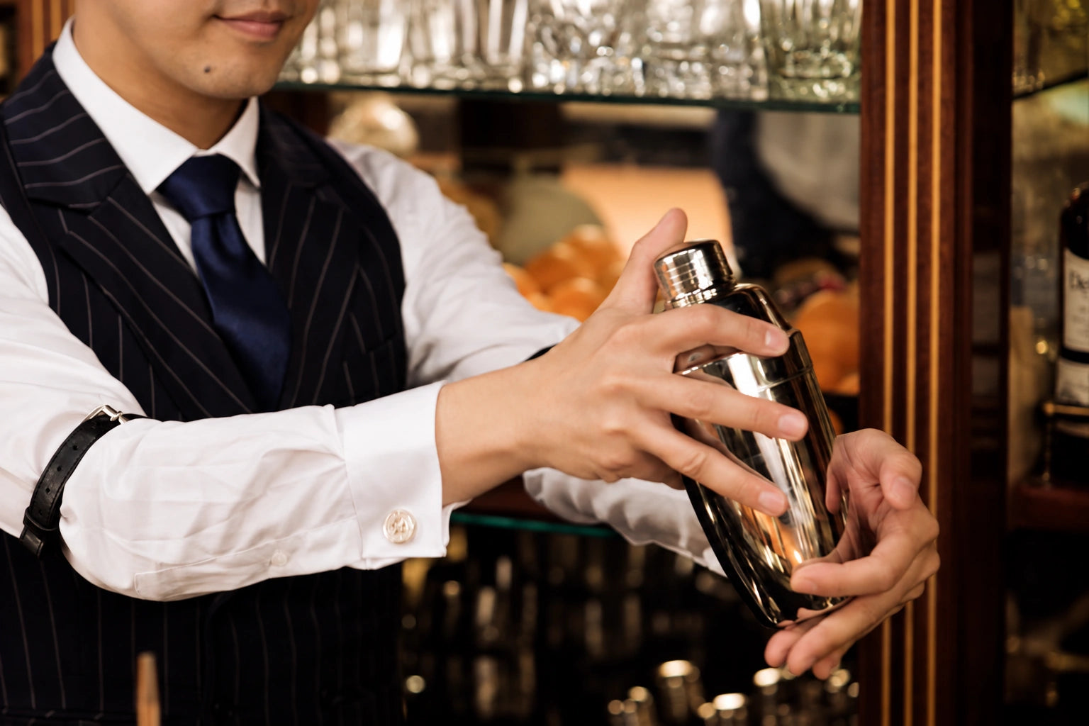 Kazuaki Nagao holding a YUKIWA cocktail shaker at the bar